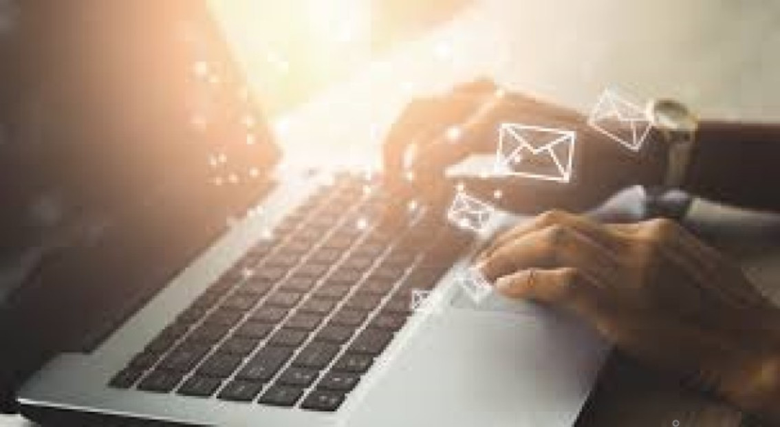 hands on a laptop with an email icon popping up from the keyboard